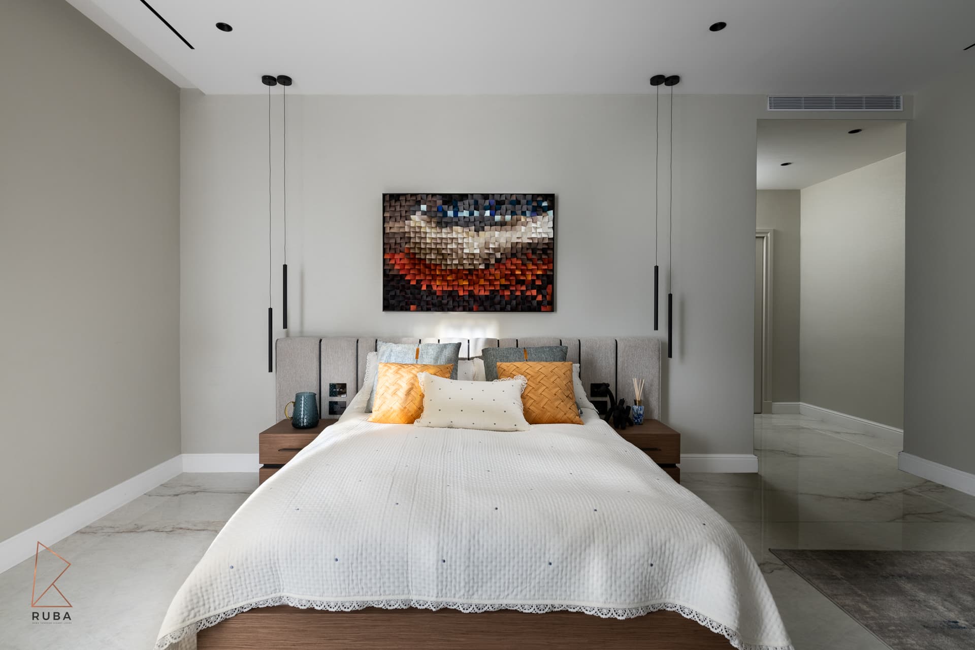 Frontal view of the bed under a textured wood mosaic artwork between slim black pendants in the second bedroom of Bird of Paradise Flower