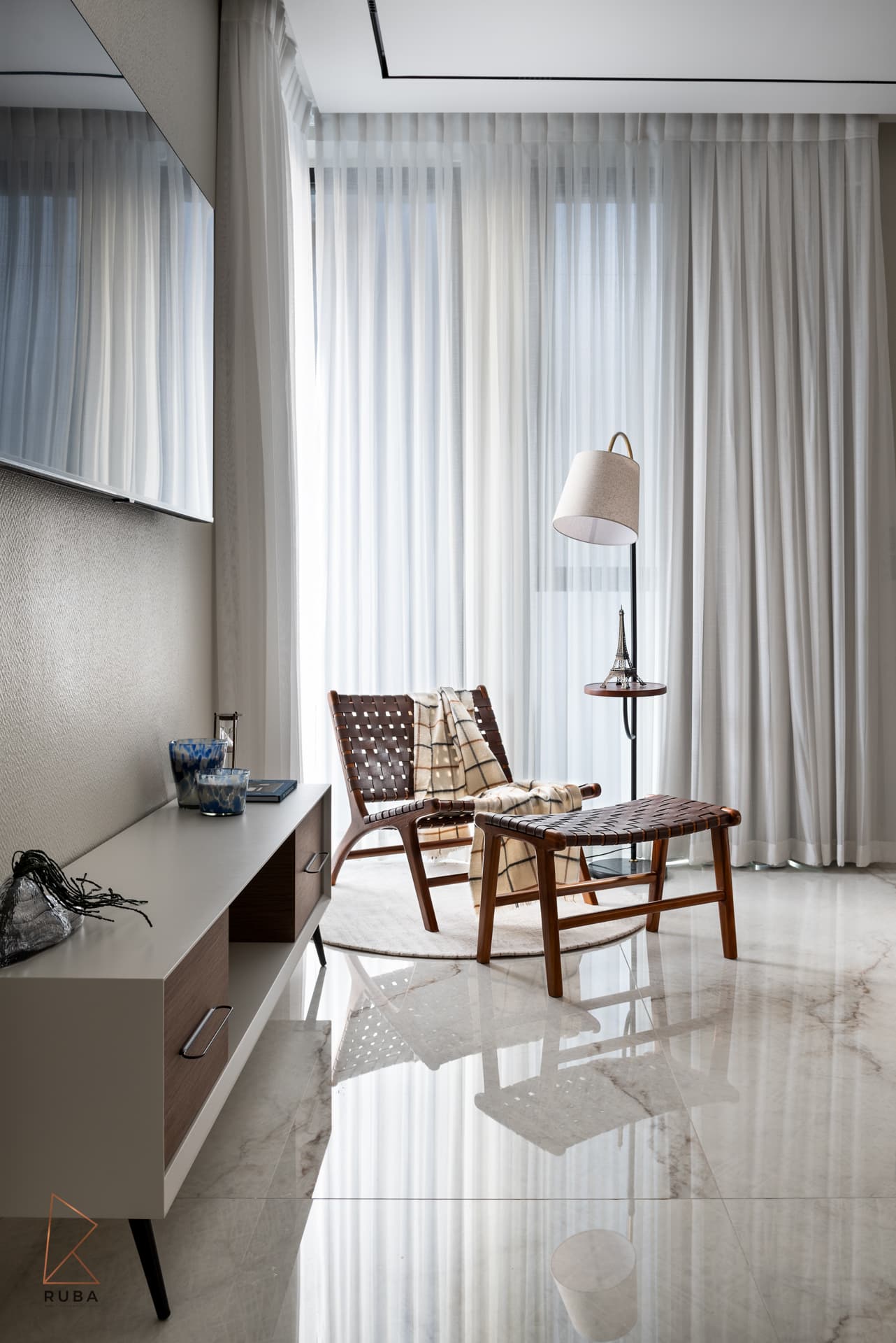 Reading corner with a woven leather lounge chair, footstool and floor lamp by sheers in the second bedroom of Bird of Paradise Flower