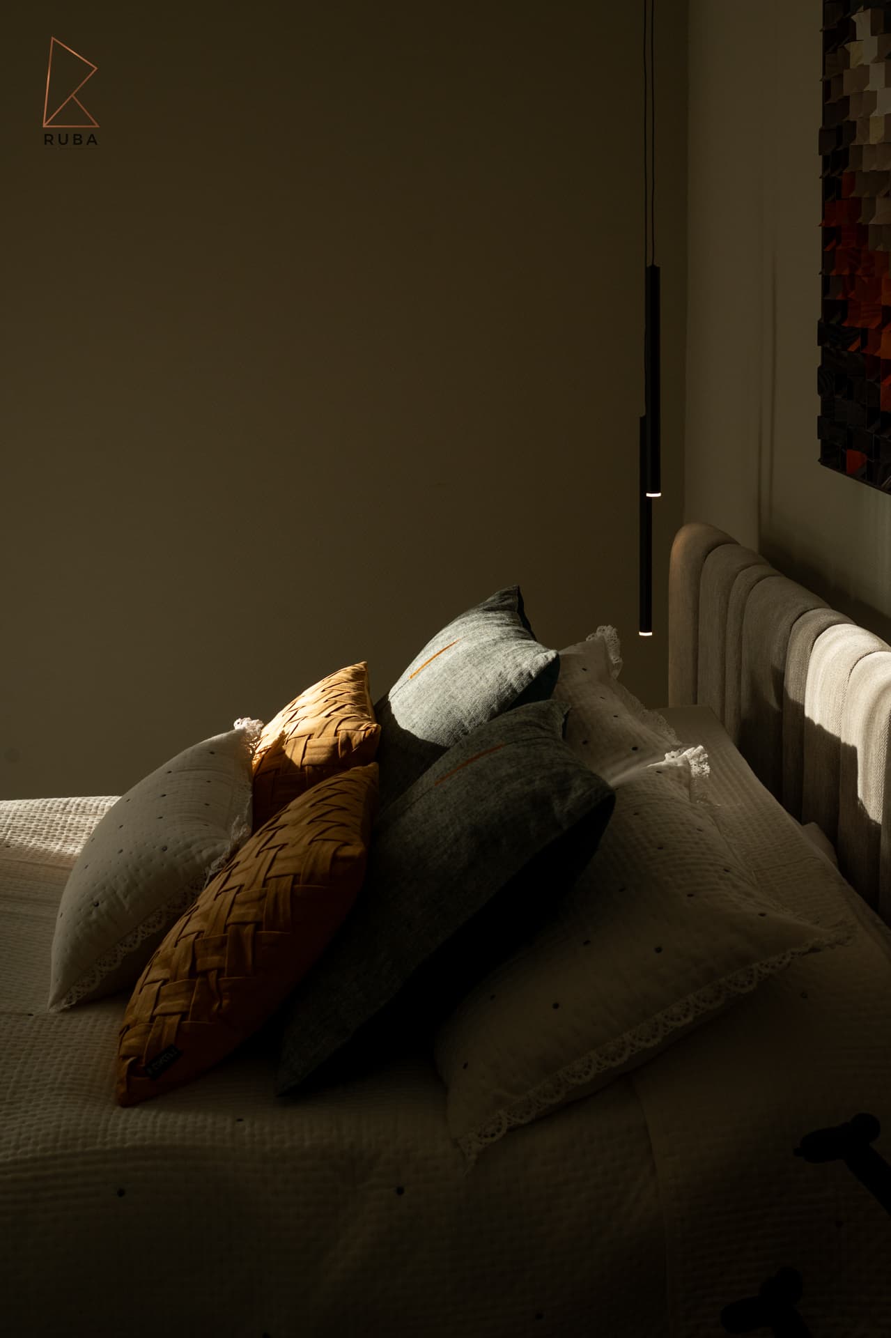 Low sunlight across woven ochre, grey and white cushions on the bed in the second bedroom of Bird of Paradise Flower