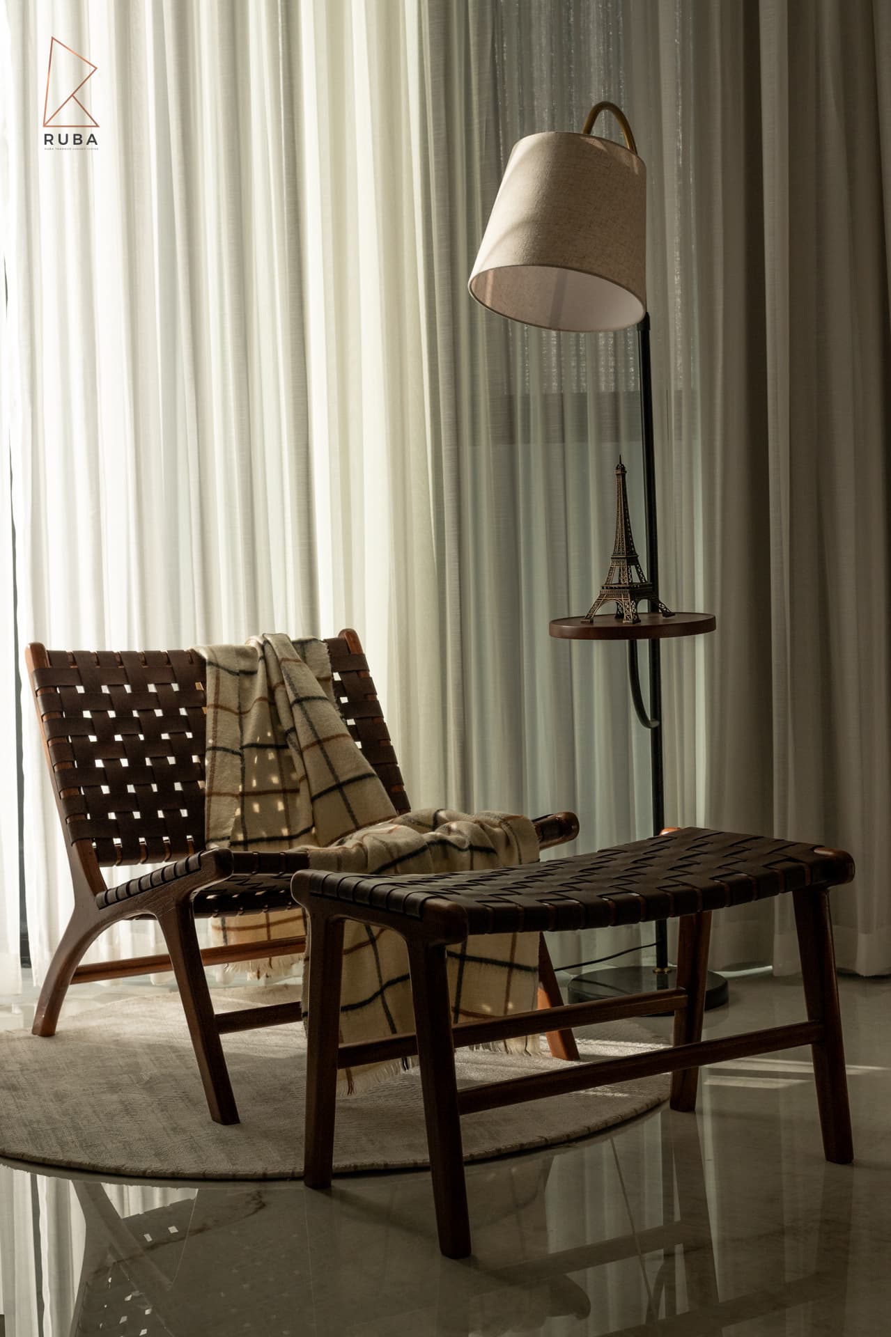 Woven leather lounge chair with a checked throw beside a floor lamp with a side shelf in the second bedroom of Bird of Paradise Flower