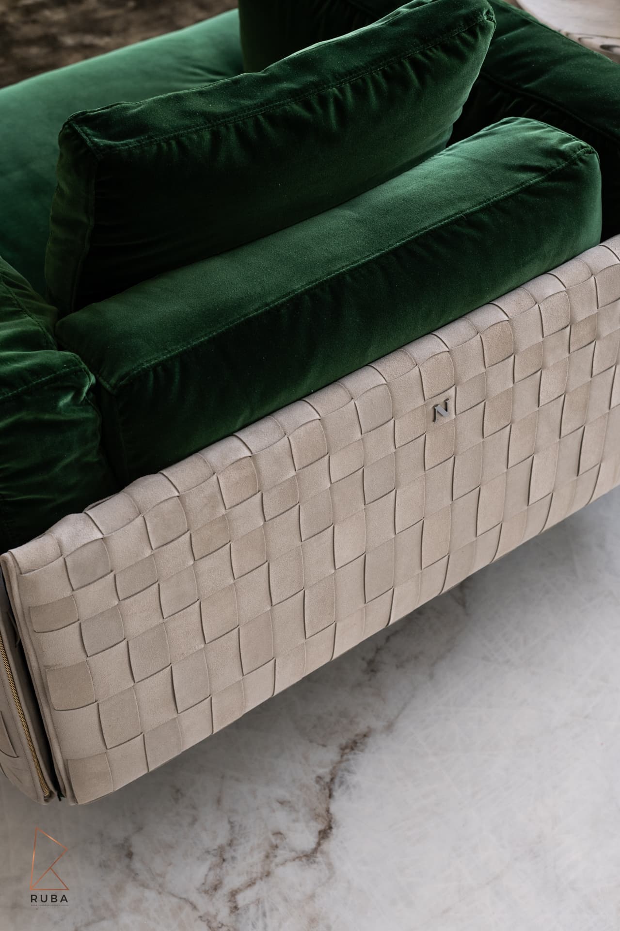 Top-down view of a green velvet armchair with a woven leather shell on marble in the living room of Bird of Paradise Flower