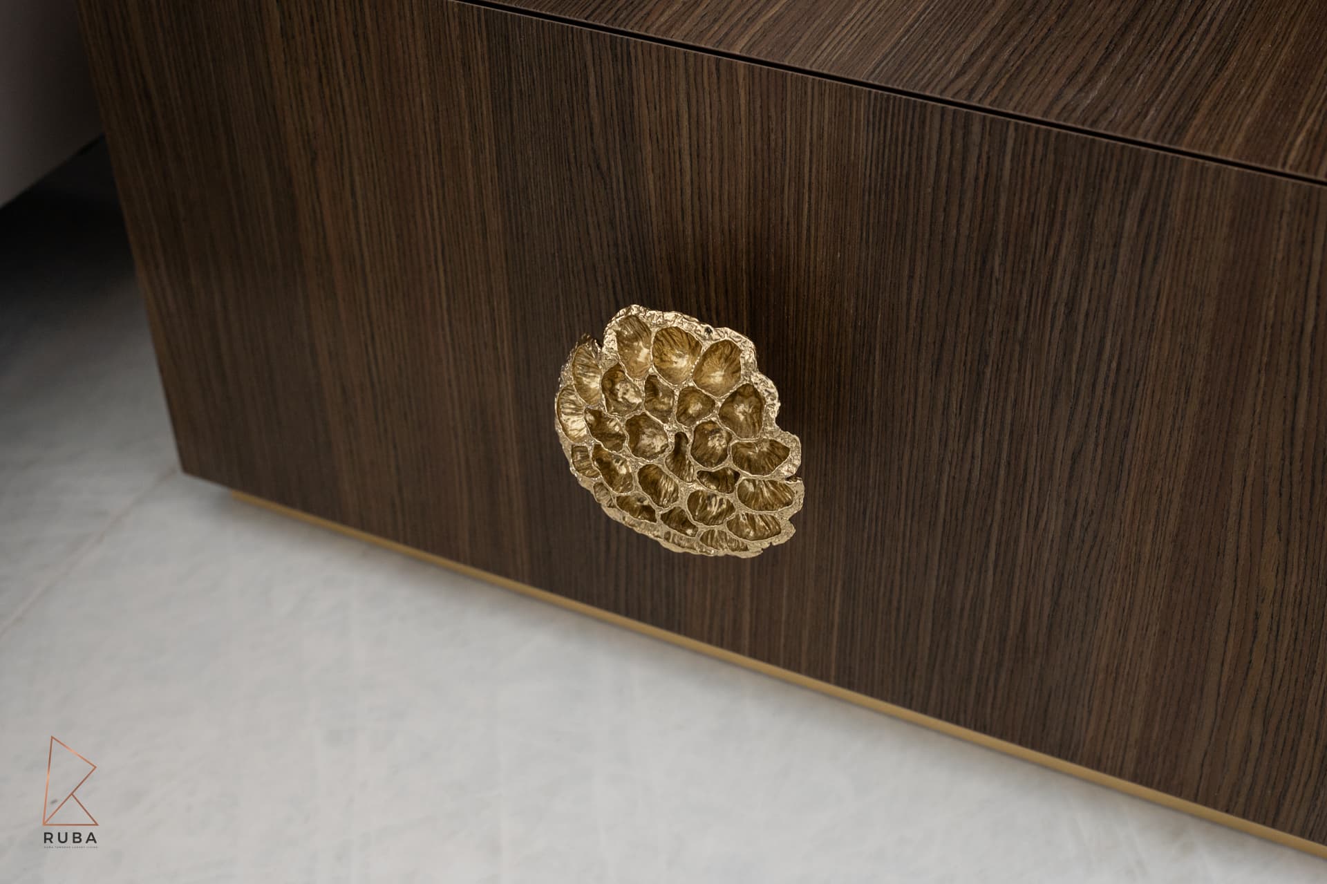 Honeycomb-textured brass pull on a dark wood nightstand drawer in the master bedroom of Bird of Paradise Flower