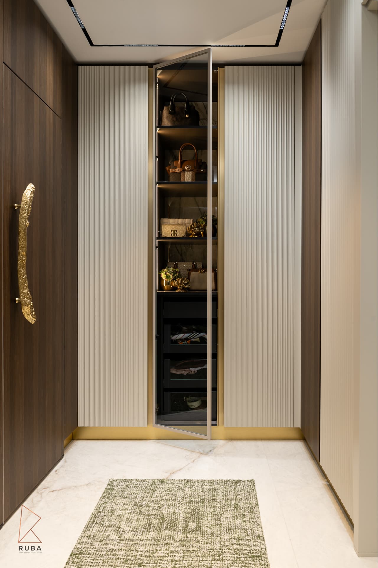 Fluted cream wardrobe doors around an open glass cabinet, with a sculpted brass pull, in the dressing room of Bird of Paradise Flower