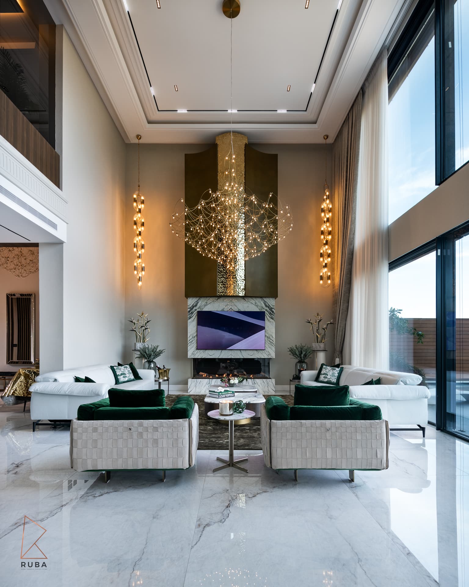 Double-height living room with the gold wire chandelier and glass chain pendants lit in Bird of Paradise Flower