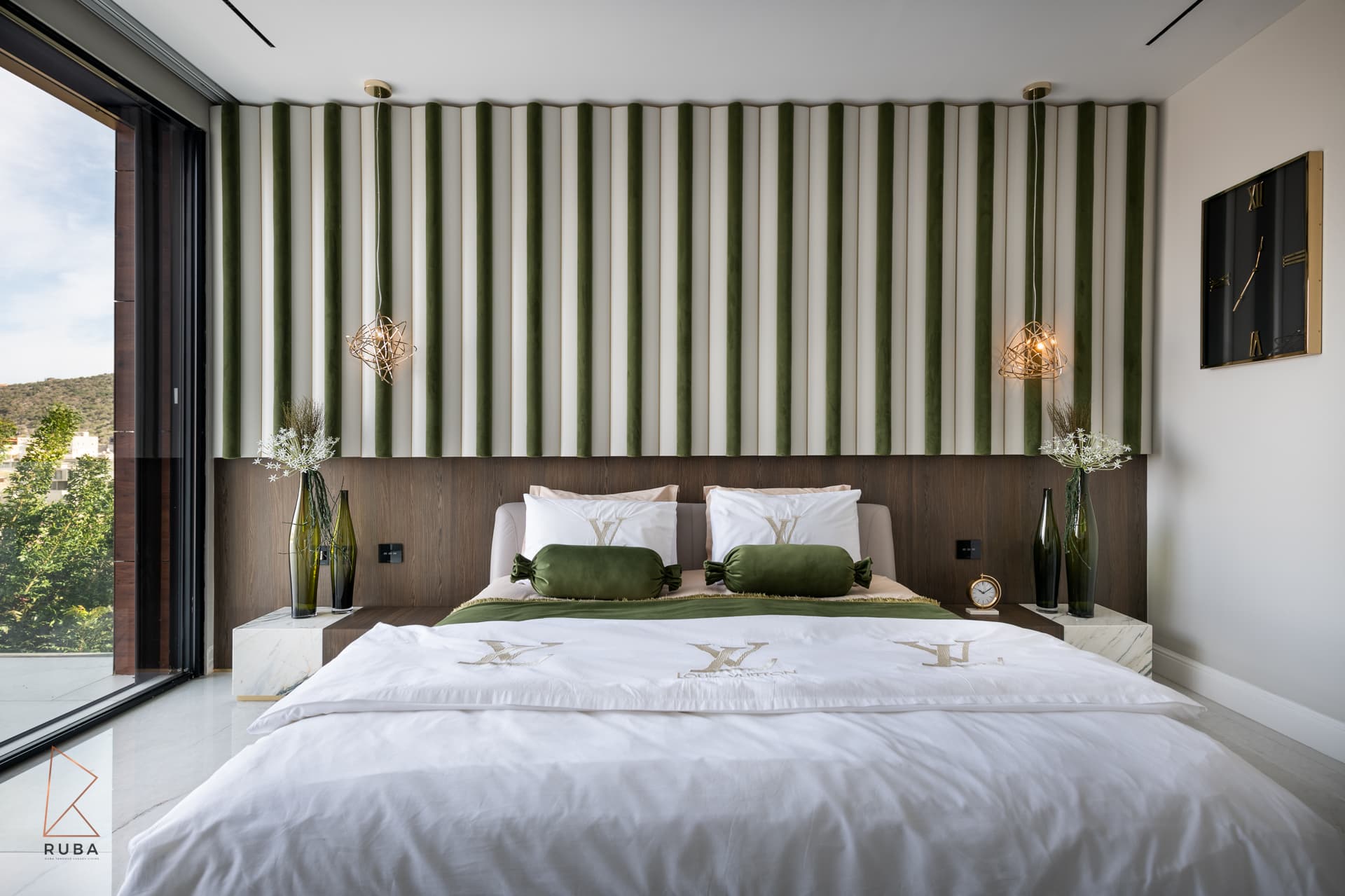 Frontal view of the bed against striped green velvet panels over a dark wood headboard in the master bedroom of Bird of Paradise Flower