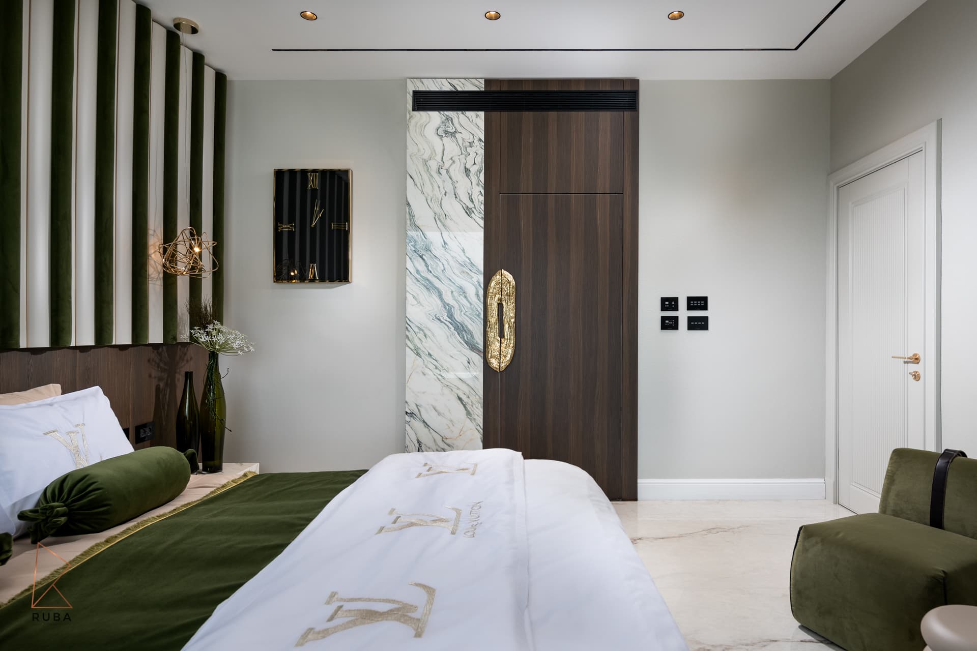 Dark wood door with a sculpted brass pull set in a veined marble strip, seen past the bed, in the master bedroom of Bird of Paradise Flower
