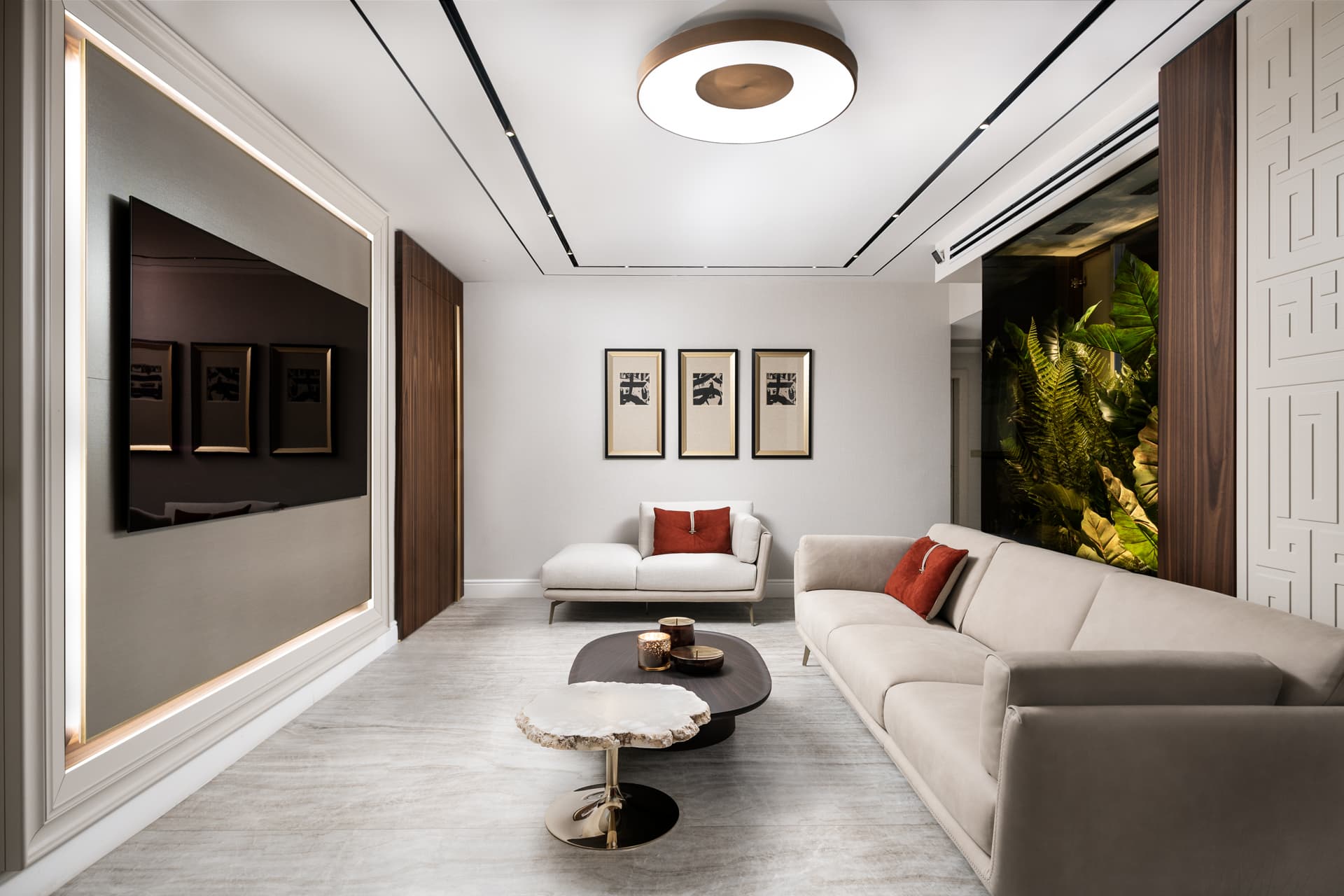 Living room with a glowing framed wall niche, cream sofa, stone-top side table and planted glass box in Born Together