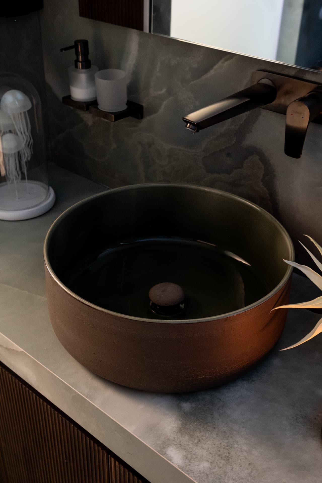 Terracotta vessel basin with a dark wall-mounted tap on a green veined stone counter in the kids bathroom of Khayyal