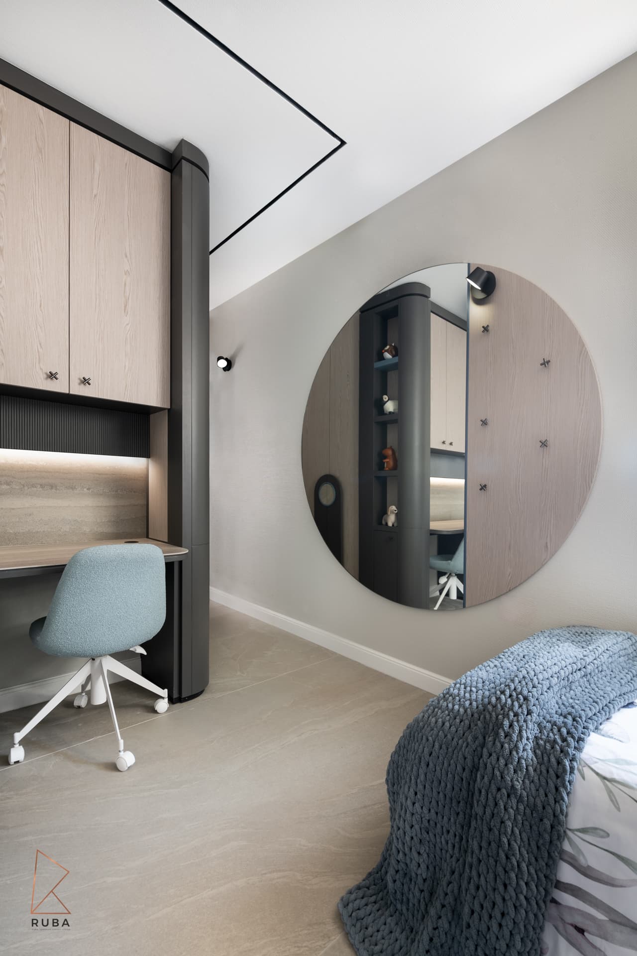 Large round mirror beside the study desk and a bed with a chunky knit throw in a kids room of Khayyal