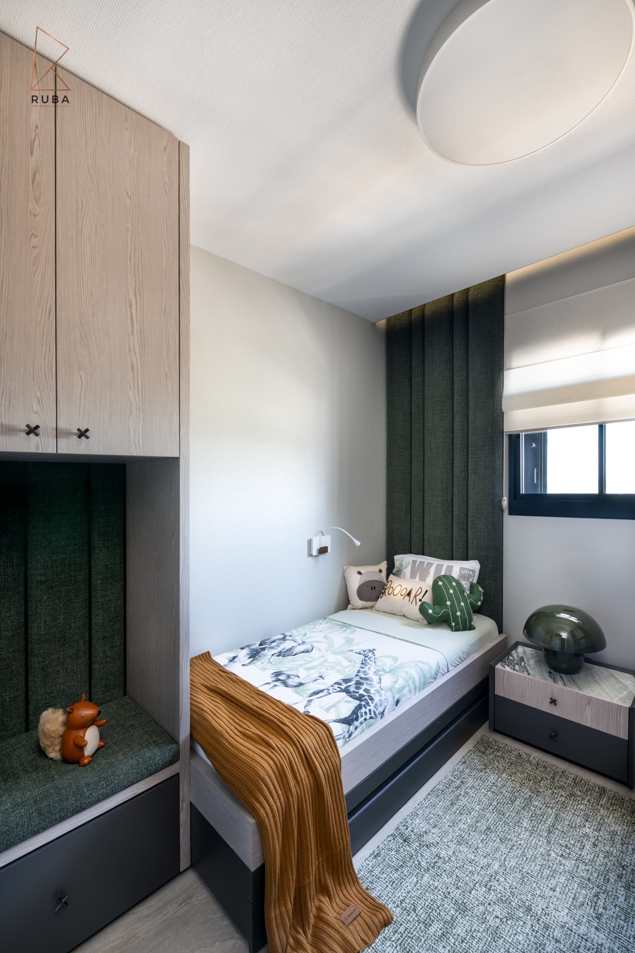 Single-bed kids room with a green upholstered wall, window seat niche and mushroom lamp on the nightstand in Khayyal