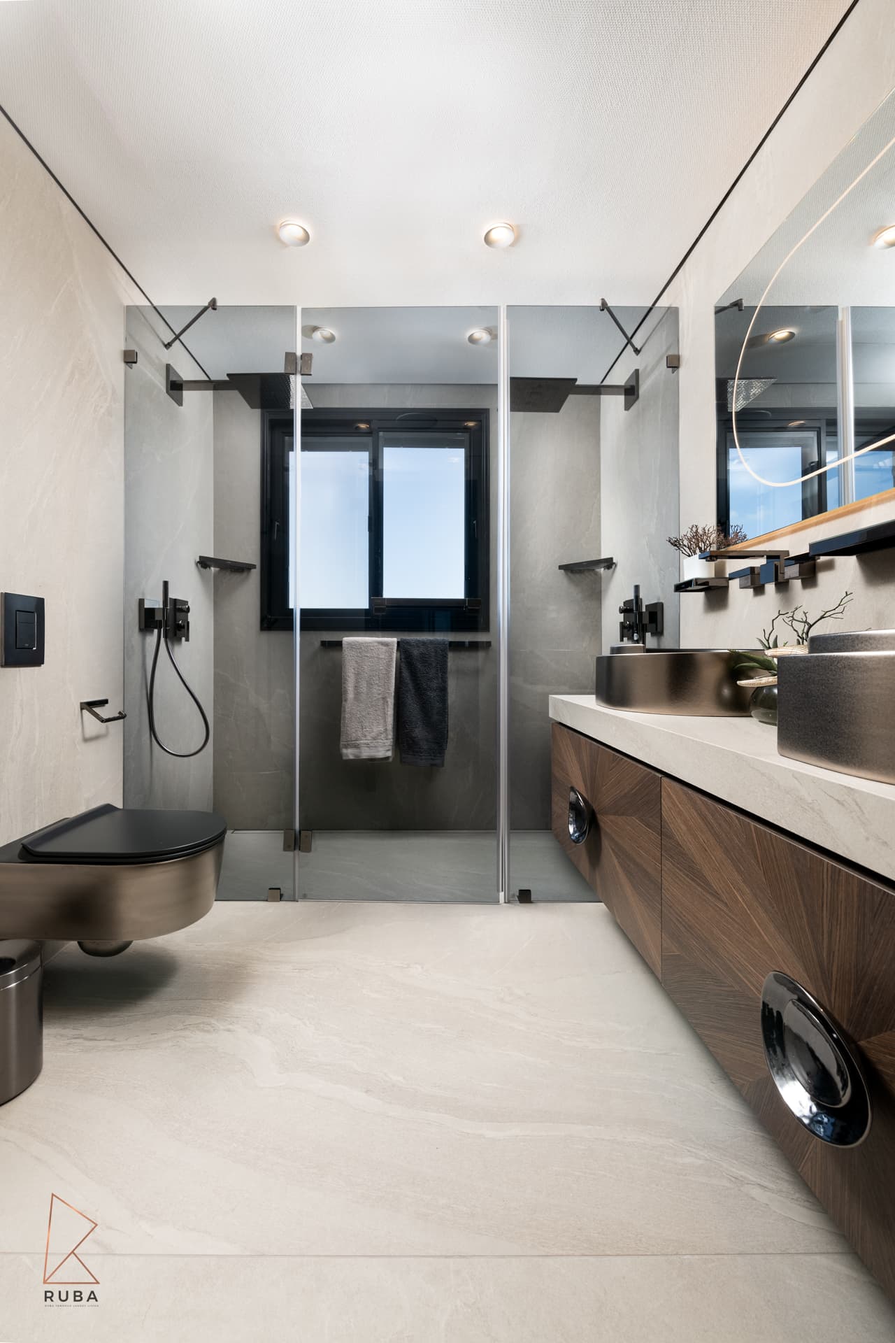 Master bathroom with a glass walk-in shower, wall-hung toilet and sunburst walnut vanity with metallic basins in Khayyal