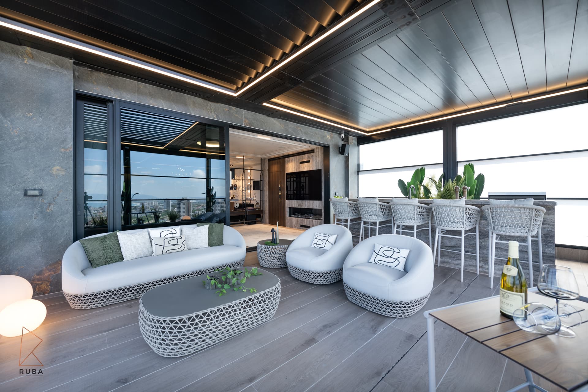 Woven lounge sofa and armchairs around a low table on the terrace, opening into the living room of Khayyal