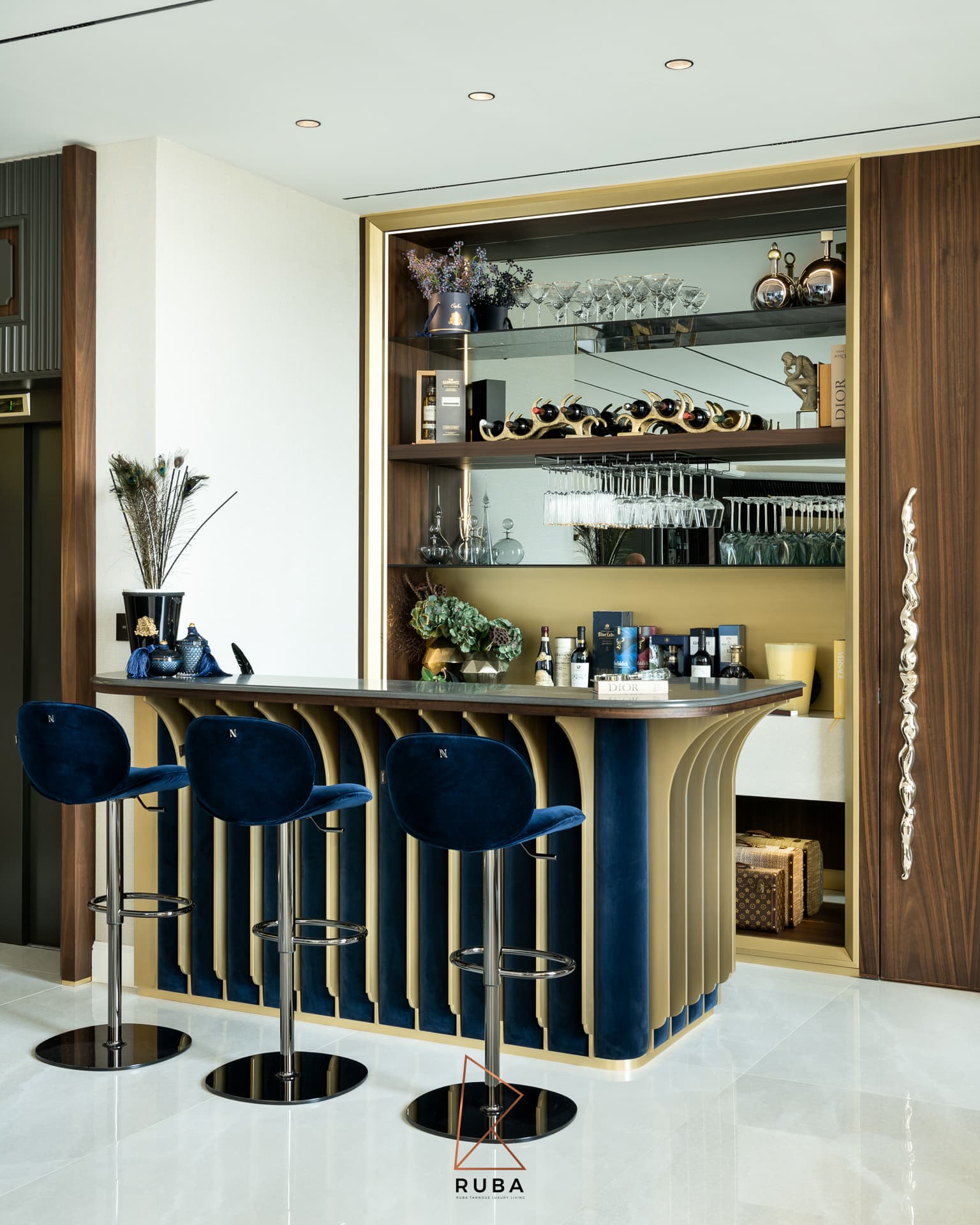 Curved bar with navy velvet panels between brass fins, blue velvet stools and mirrored glass shelving in Patagonia