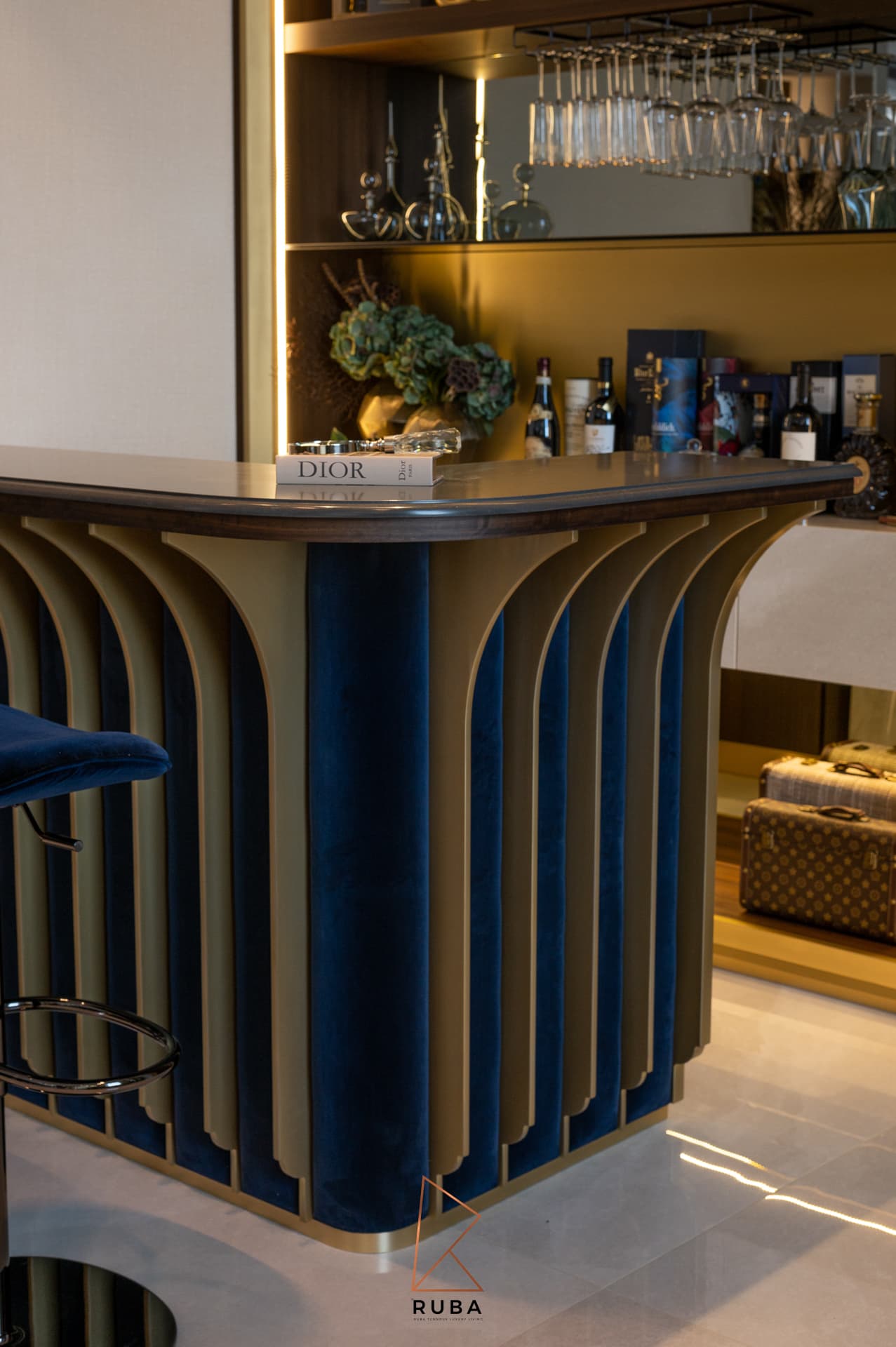 Corner of the bar counter showing navy velvet panels between flared brass fins in the bar of Patagonia