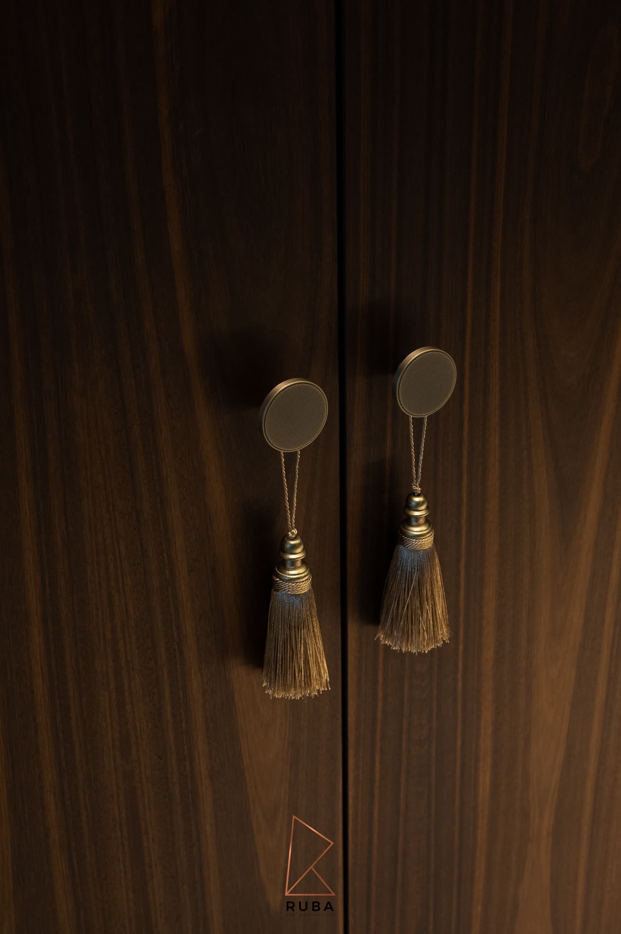 Round brass knobs with hanging silk tassels on walnut wardrobe doors in the dressing room of Patagonia