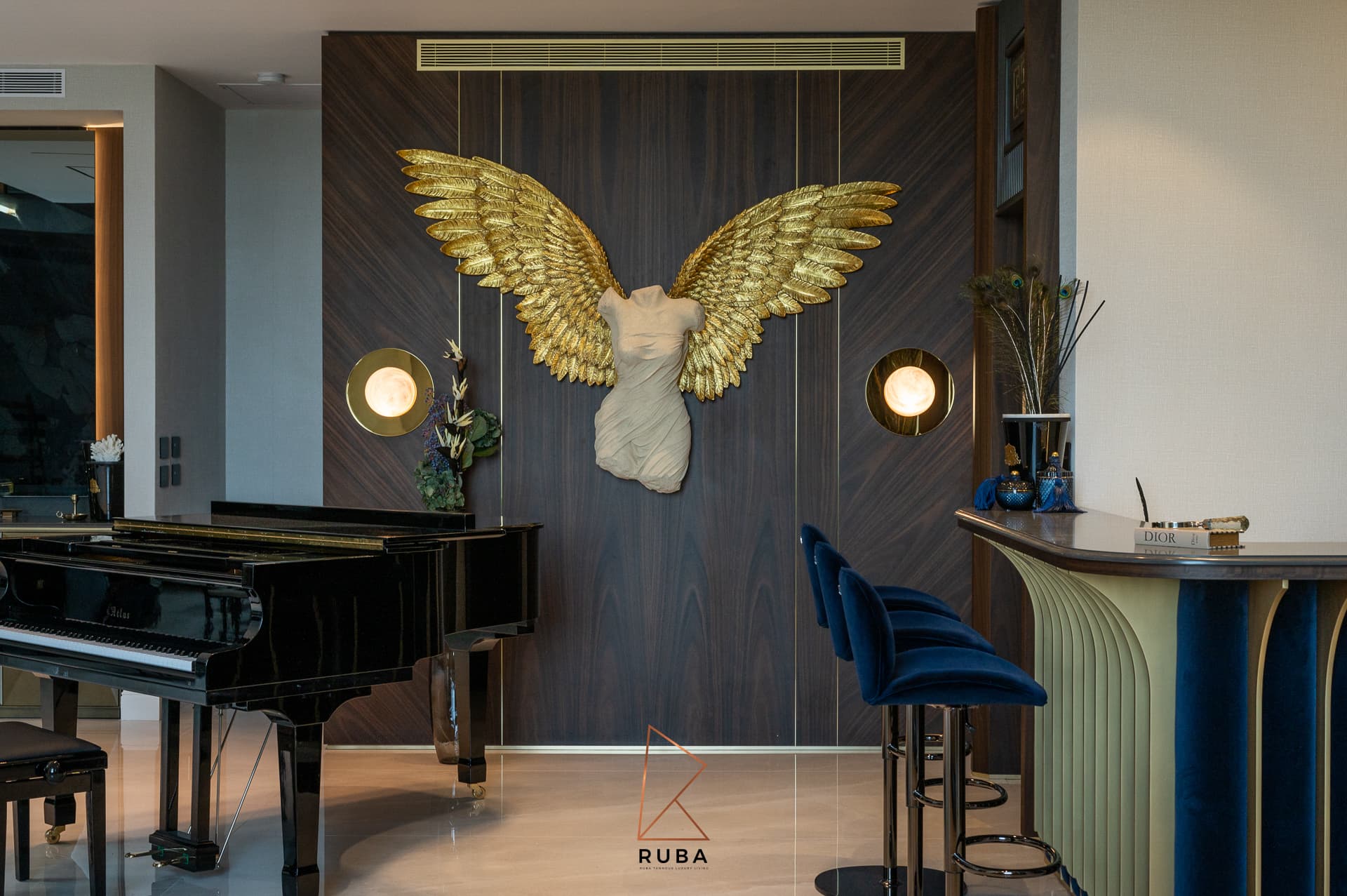 Gold-winged torso sculpture between globe wall lights, flanked by a grand piano and velvet bar stools in Patagonia
