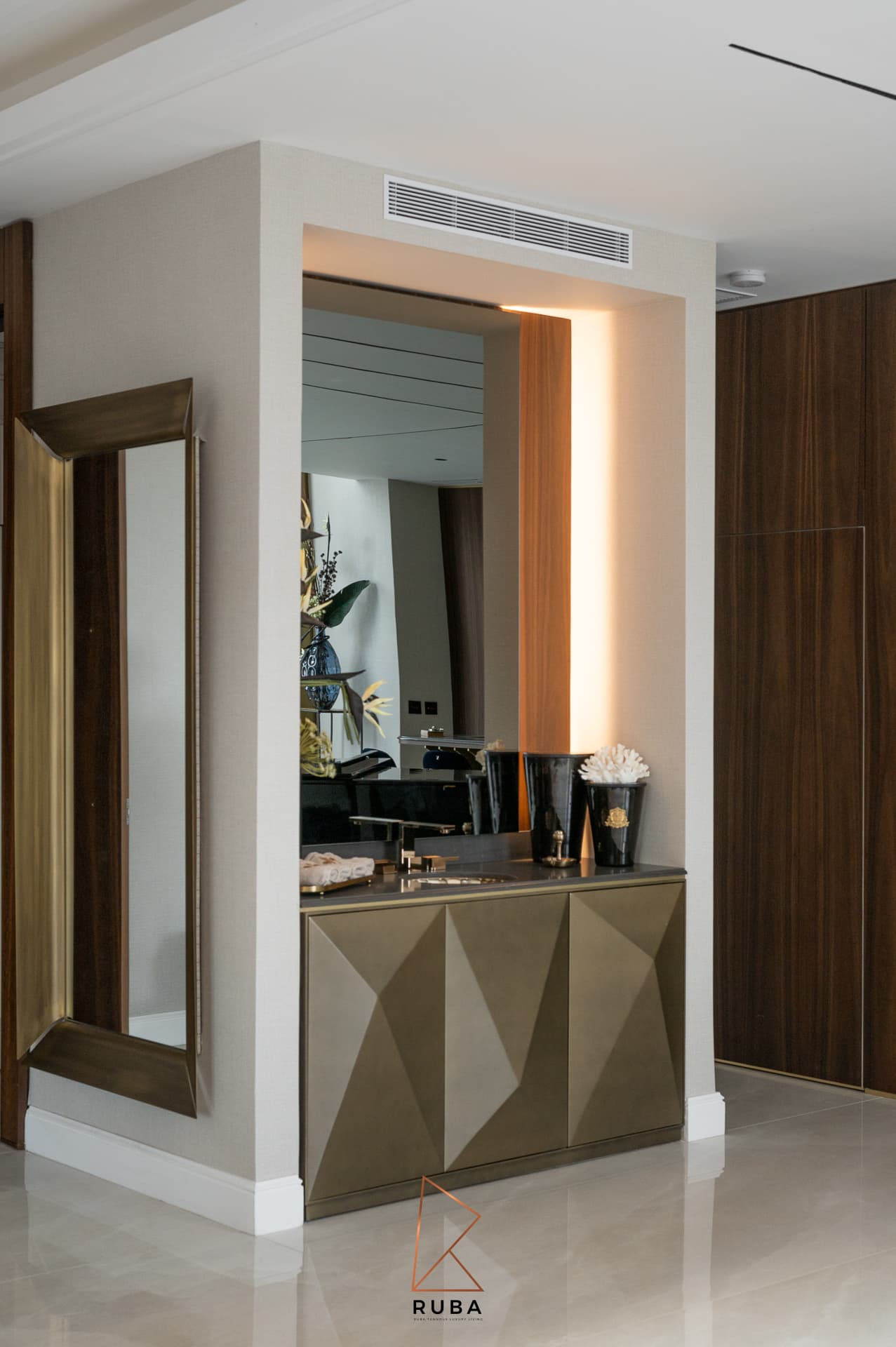 Angled view of the entrance vanity niche beside a tall brass-framed floor mirror in Patagonia