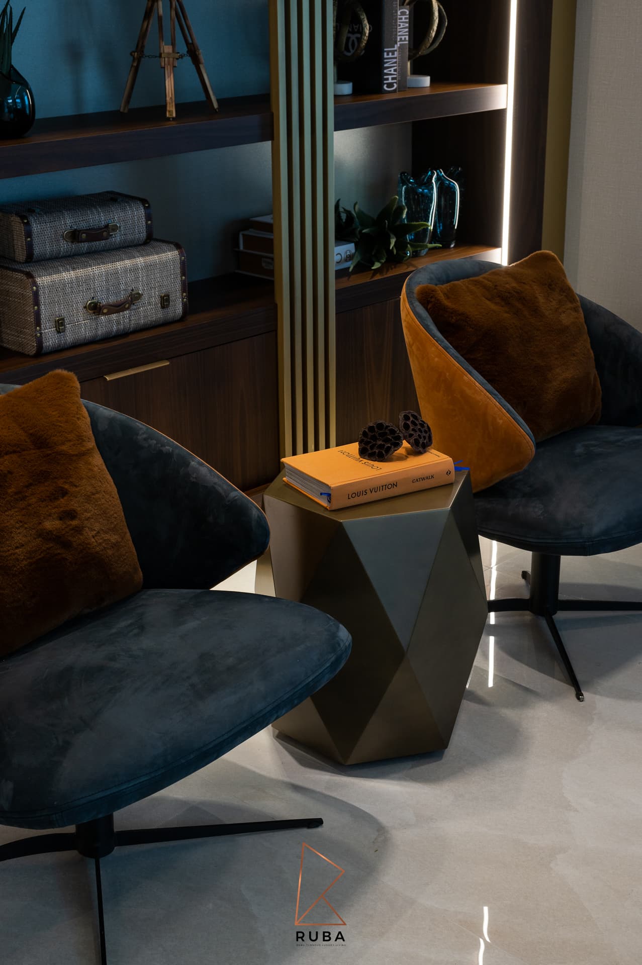 Grey velvet swivel chairs with rust fur cushions around a faceted metal side table in the family room of Patagonia