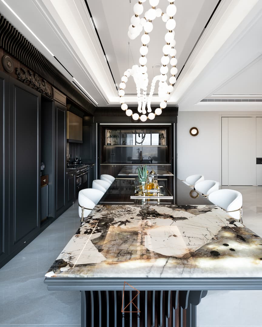 Kitchen island with a backlit veined stone top, white counter stools and a beaded glass chandelier in Patagonia