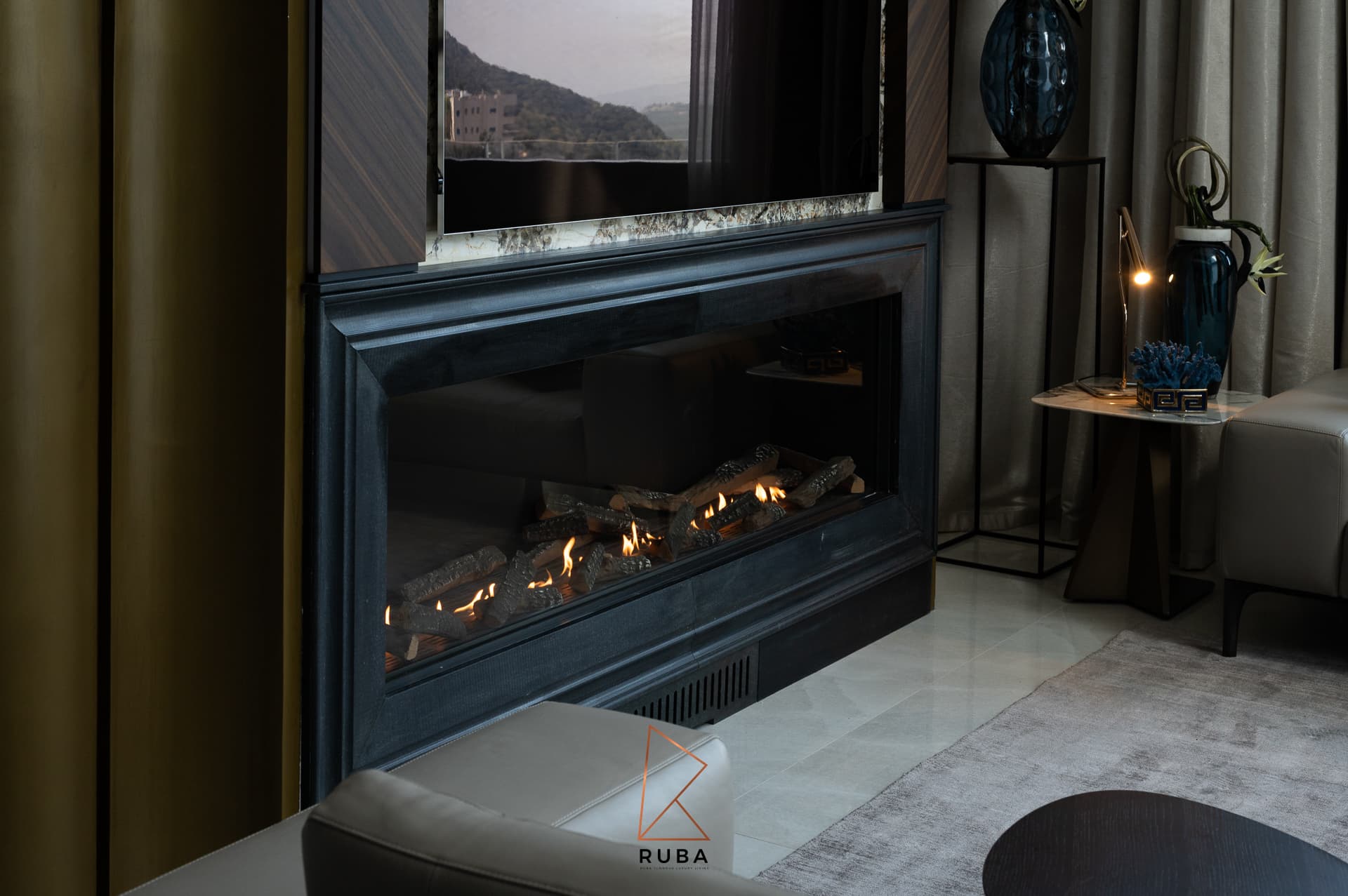 Linear gas fireplace in a dark stone surround below a veined stone ledge in the living room of Patagonia