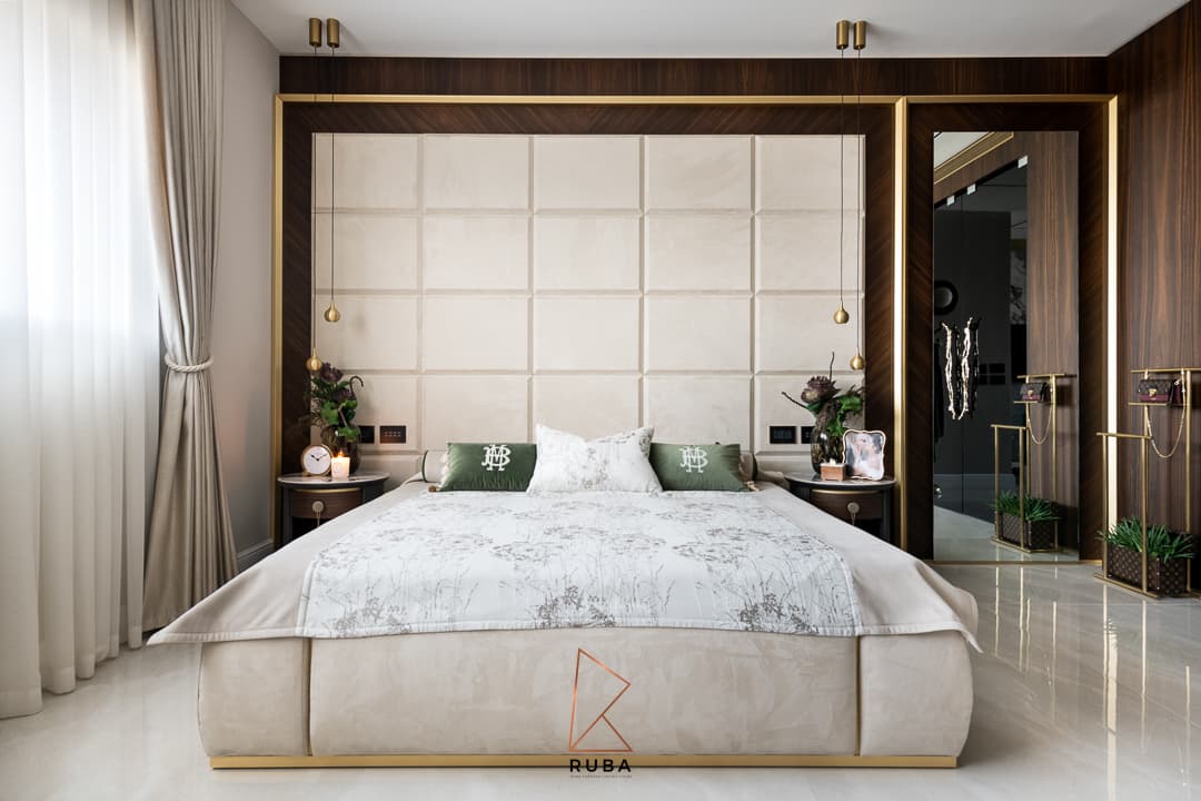Frontal view of the bed against a cream padded headboard wall framed in walnut and brass in the master bedroom of Patagonia
