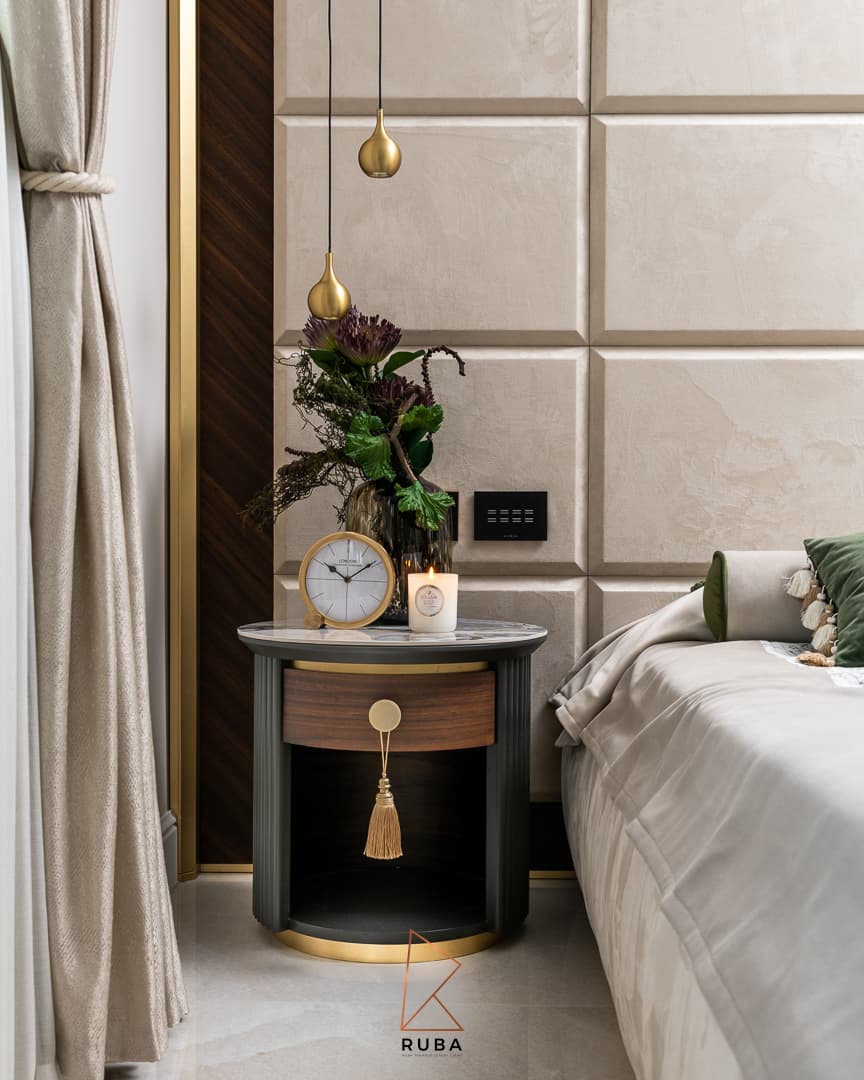 Round walnut and black nightstand with a brass tassel pull under a brass teardrop pendant in the master bedroom of Patagonia