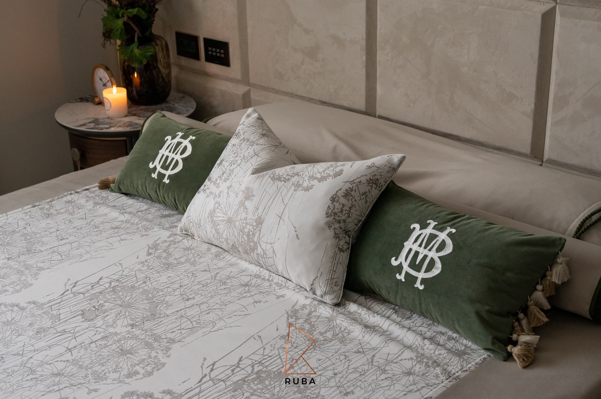 Embroidered green velvet cushions and a botanical print pillow on a cream bed in the master bedroom of Patagonia