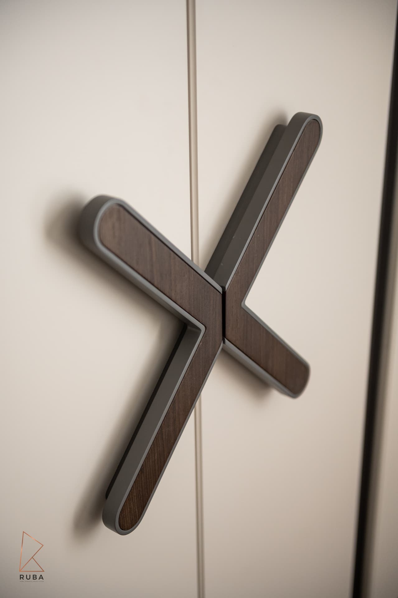 Cross-shaped walnut handle with a grey frame spanning two cream wardrobe doors in a kids bedroom of The Last Supper