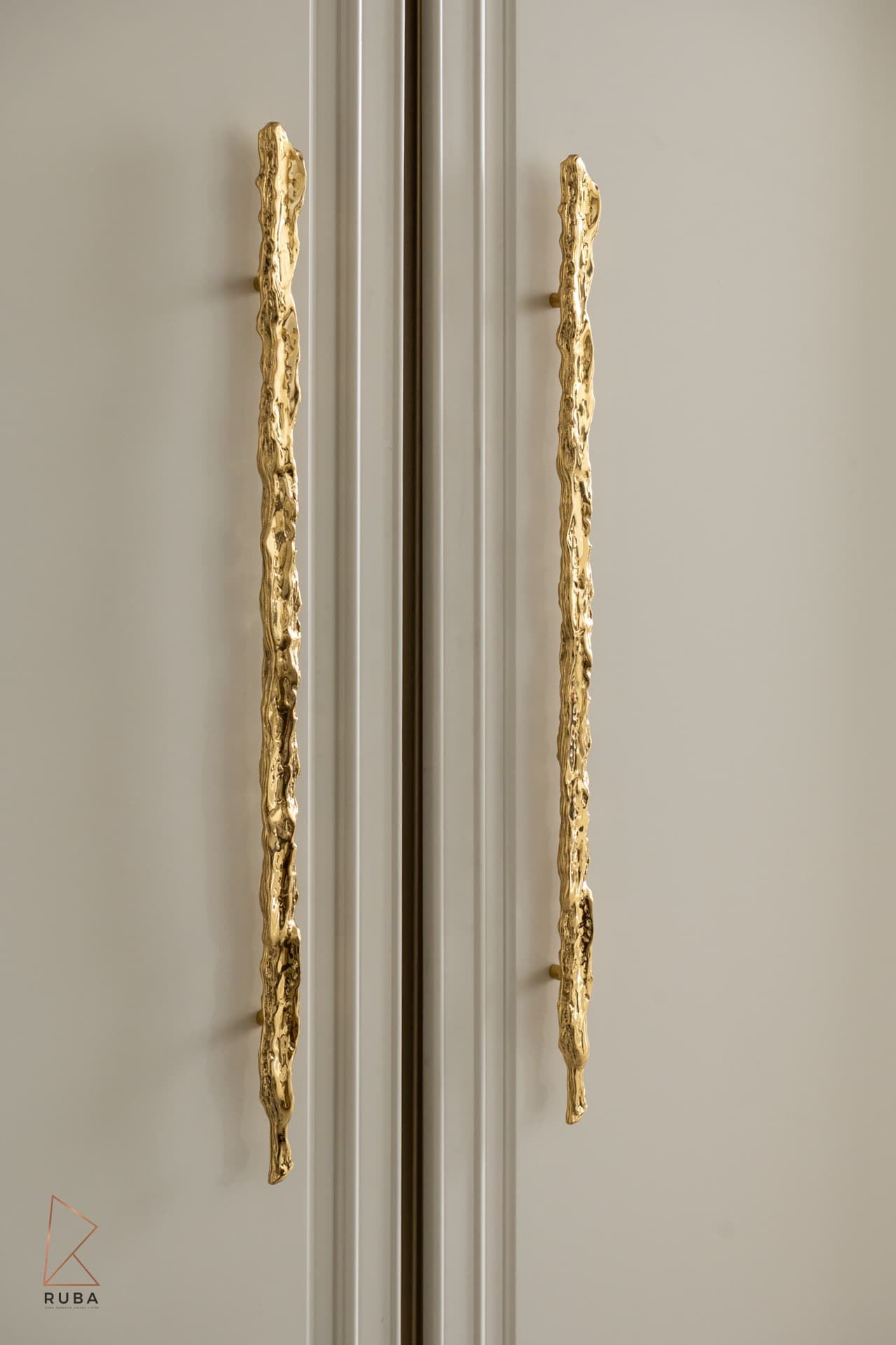 Pair of long organic brass pulls on cream panelled cabinet doors in the dining room of The Last Supper