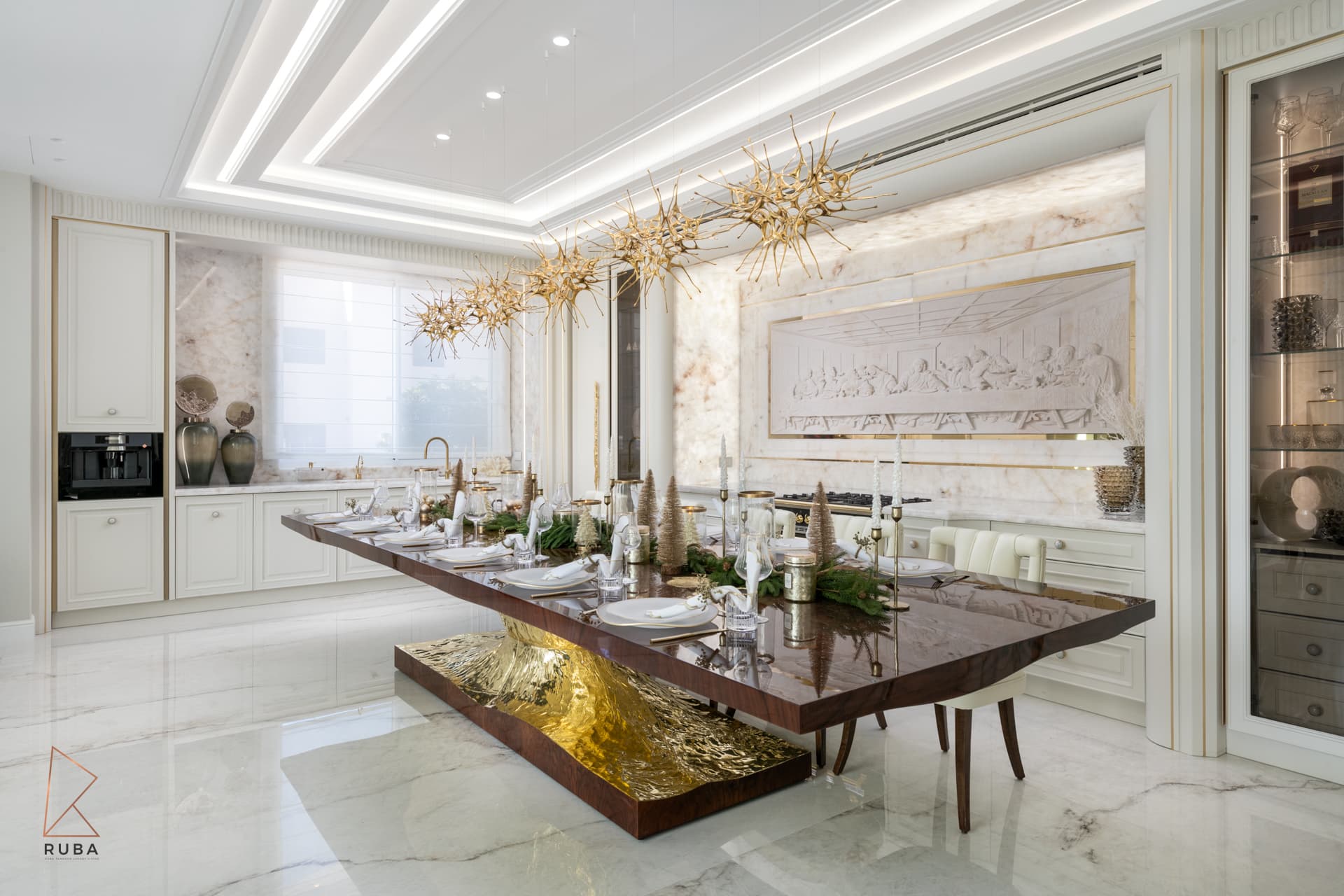 Angled view of the dining table with its sculpted gold base beside an onyx backsplash and cream cabinetry in The Last Supper