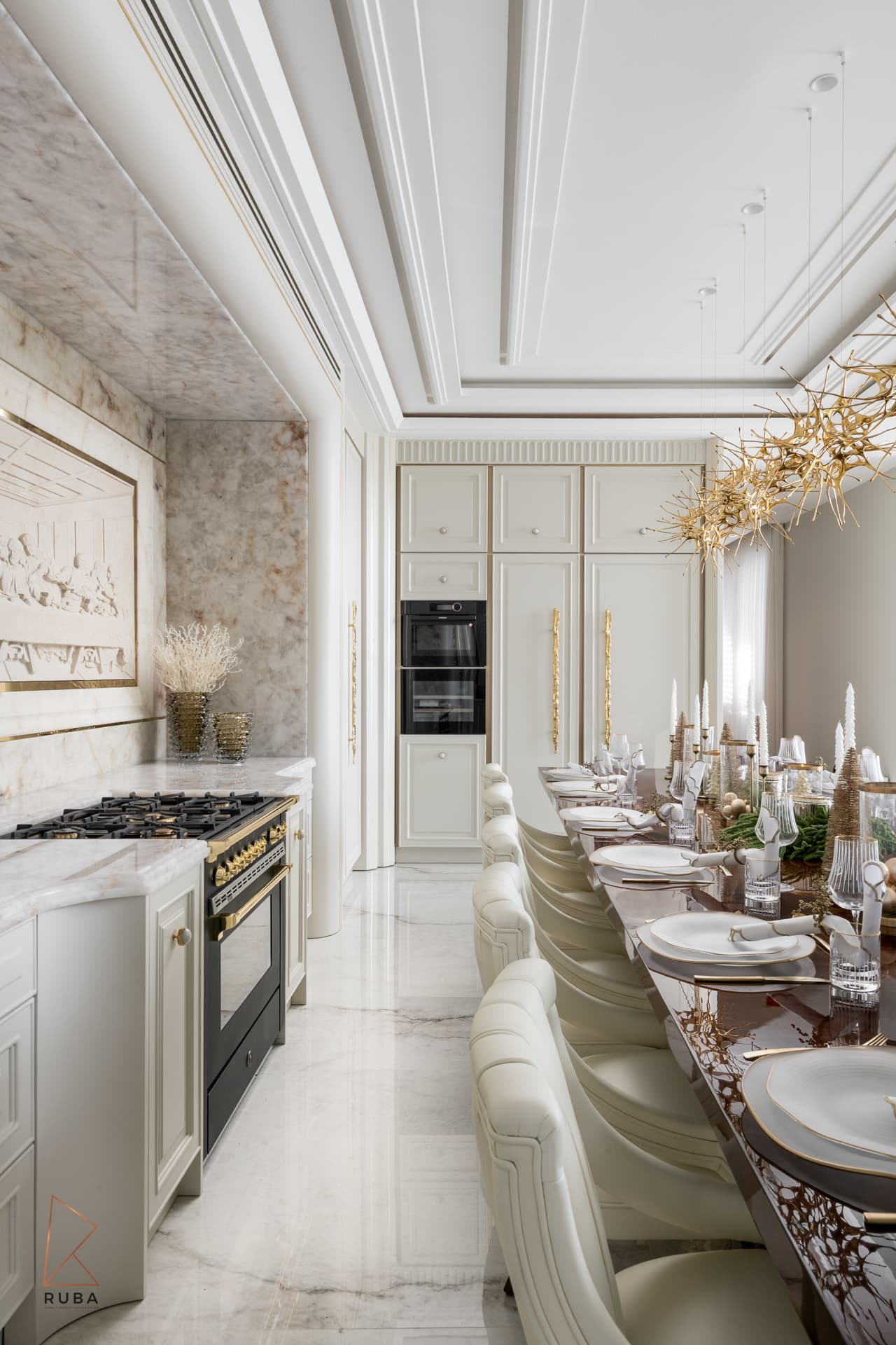 Long view of the dining table beside the kitchen range with a relief panel on an onyx wall in The Last Supper