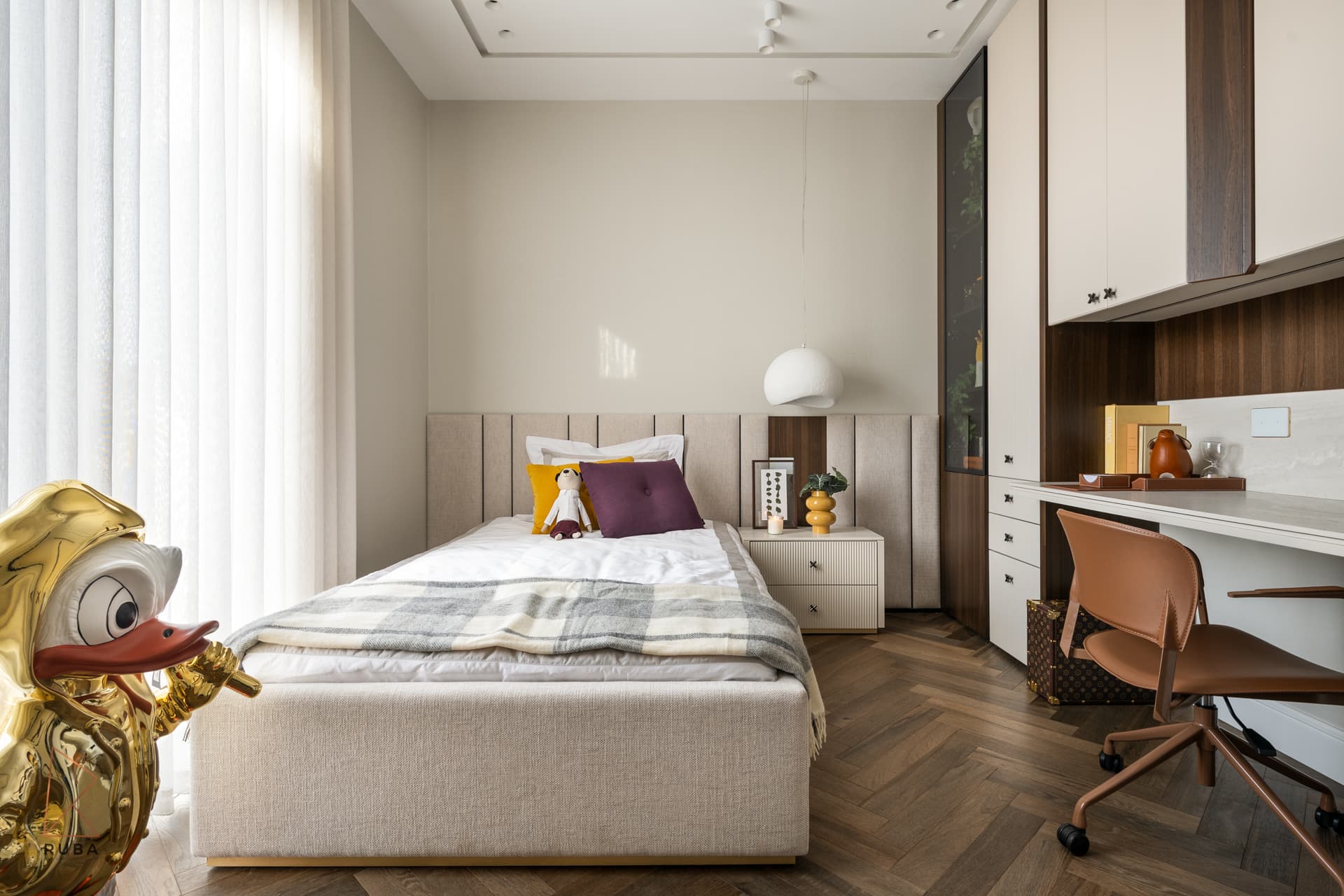 Kids bedroom with a panelled headboard, built-in desk under walnut-trimmed cabinets and a gold duck sculpture in The Last Supper