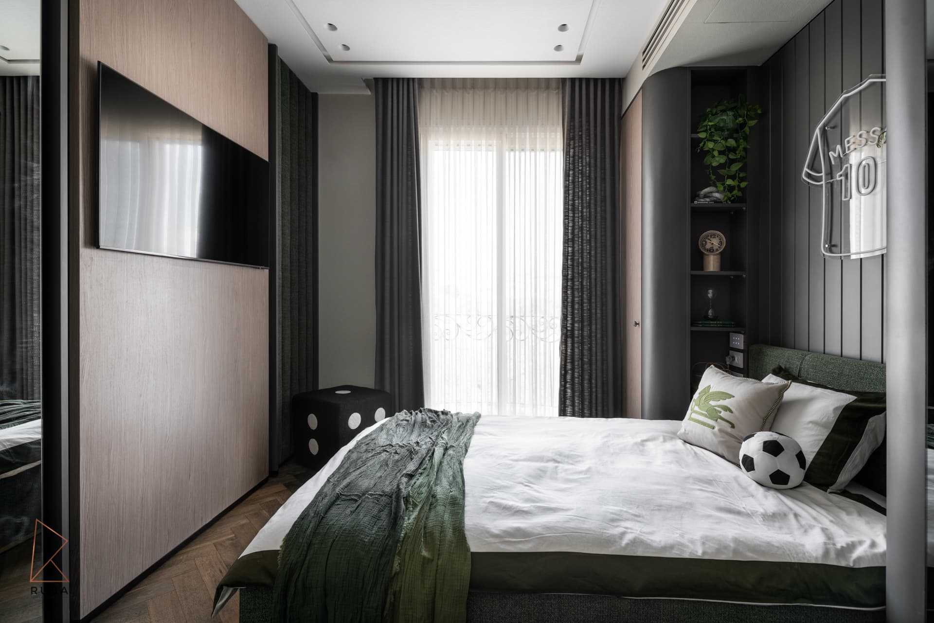 Kids bedroom with a wall-mounted screen on oak panelling opposite a green upholstered bed in The Last Supper