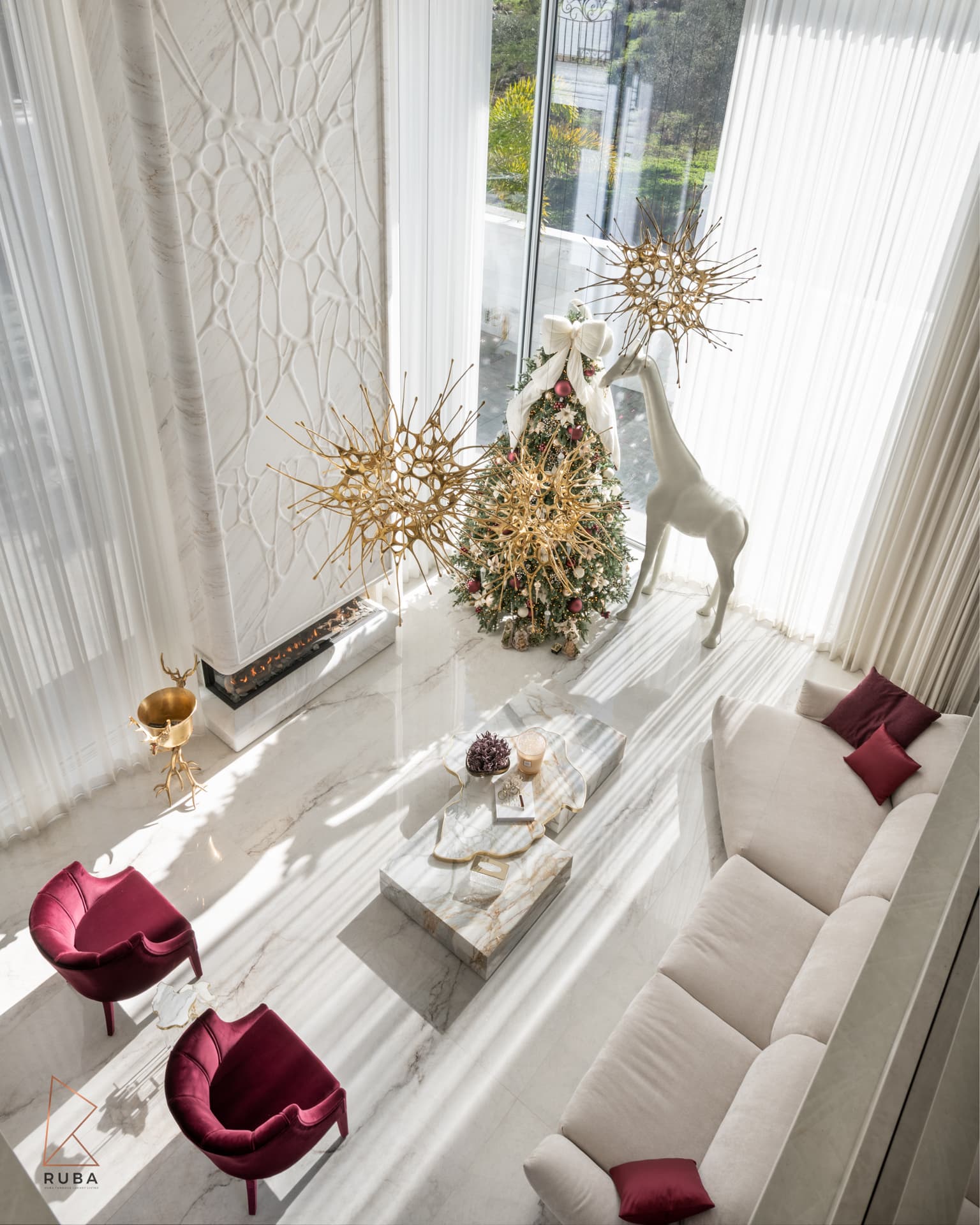 High overhead view of the living room showing a sculpted white stone wall, stone block coffee tables and cream sofa in The Last Supper
