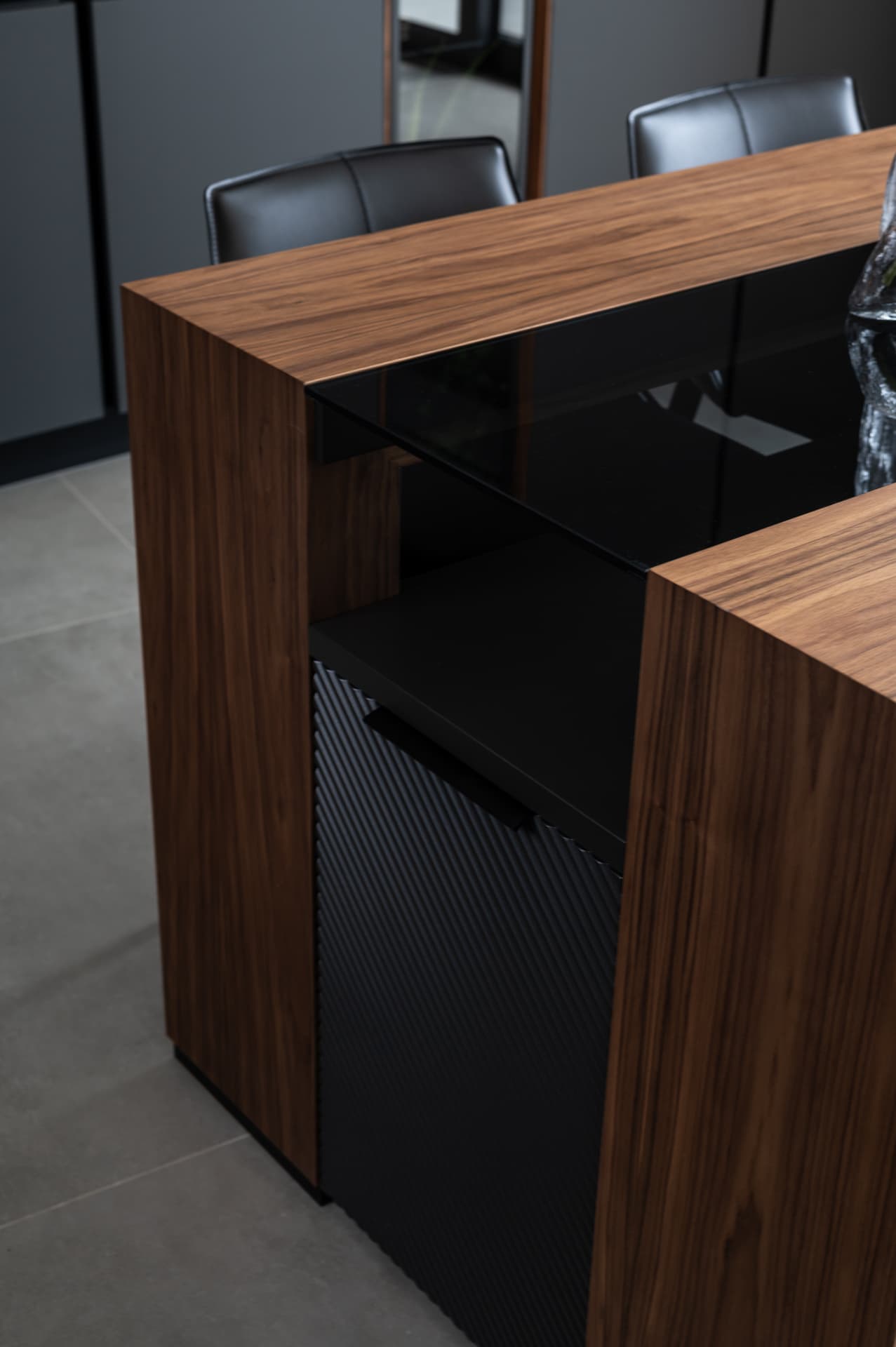 Waterfall walnut island edge with a smoked glass inset and ribbed black cabinet door in Timeless Union