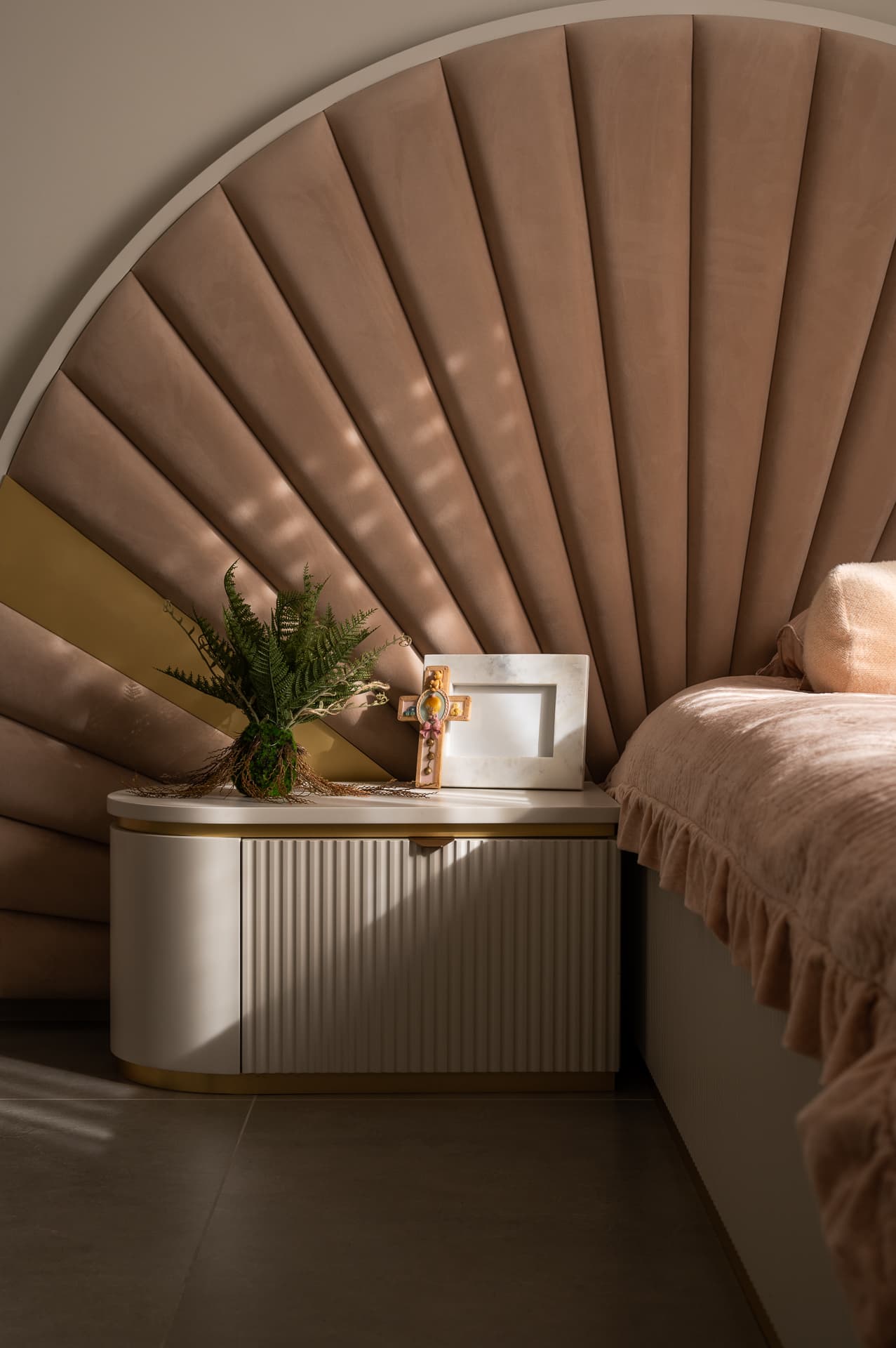 Fluted white bedside unit with brass base under a channel-tufted blush velvet headboard in the girls room of Timeless Union