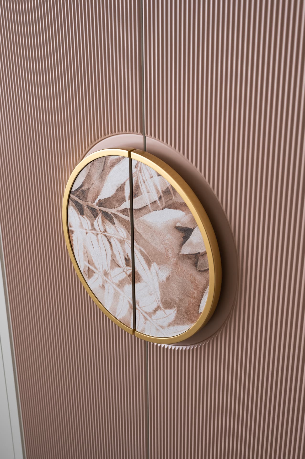 Round brass-rimmed botanical handle set into blush fluted wardrobe doors in the girls room of Timeless Union